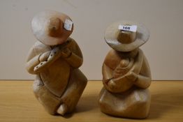 Two hand made Mexican figural ornaments of mother and child and musician, the largest measures