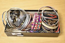 A collection of bangles of various design including a thick engraved buckle style closure bangle,