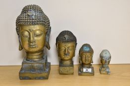 A group of four brass Buddha busts, of graduating sizes, the largest measures 32cm tall