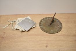 An antique brass sundial, having Welsh dragons to centre, approx 17cm, sold with a Heliograph