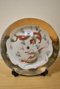 A Chinese plate, having dragon and rooster depicted to centre with gilt edging.