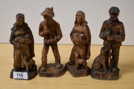 Four 20th Century continental wooden studies of figures with dogs, the largest measures 17cm tall