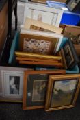 A carton of assorted pictures and prints with a variety of scenes.