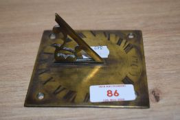 A novelty brass sun dial, in the form of a clock face with Roman numerals, etched date of 1709,
