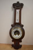 A Victorian wall hanging oak barometer with thermometer.