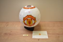 A Danbury Mint Manchester United Champions Trophy Glazed life sized Porcelain Football on display