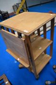An early 20th Century golden oak revolving bookcase, with fold out book/music stand to top (on later