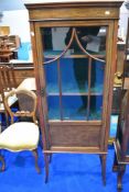 An Edwardian mahogany and inlaid narrow display cabinet having foliate inlay decoration,