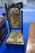 A 19th Century low chair having foliate and twist frame with later upholstery, prayer or nursing