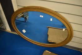 A gilt frame oval wall mirror