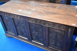 A traditional oak kist having carved panel decoration, approx dimensions W153 D60 H75cm