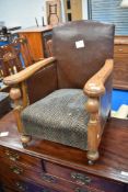An early 20th Century childs stained frame armchair with leather sides and moquette seat, dimensions