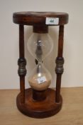 A 19th century maritime hour glass, having three spindles meeting in centres with metal cuffs and