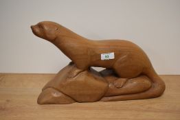 A carved hardwood depiction of an otter, approx 43cm long.