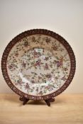 A large continental charger, having hand painted decoration of sprigs of flowers in pinks, brown,