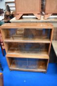 A minty or similar stacking bookcase, in oak having three tiers and castors