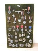 A collection of WWII German Medals and Badges including Iron Cross with ribbons x2, War Merit