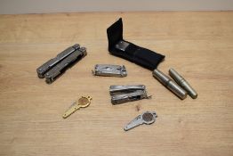 An assorted collection of multi-tools, vintage corkscrews, and two early 20th Century Farthing