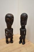 Two African carved hardwood tribal statuettes, to include a West African fertility figure, both