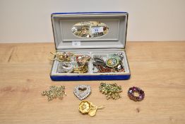 An assortment of costume brooches including a large statement owl brooch, a variety of paste set