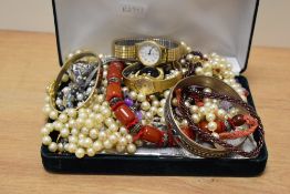 A green velvet jewellery box containing an assortment of costume jewellery including beaded