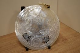 A finely carved and pierced Mother-of-Pearl shell, of circular form with depiction of Jesus above