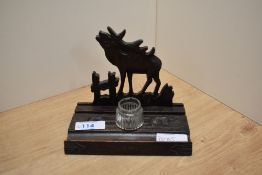 A carved treen ink well/pen stand of primitive form, bearing inscription, having Moose decoration to