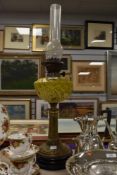A Victorian brass based oil lamp with yellow glass reservoir, approx 71cm.