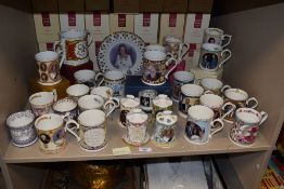 A collection of approximately 24 commemorative ware mugs, four bells and a plate from the Peter