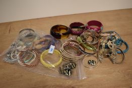 A collection of costume bracelets including faux pearls, thin bangles, statement bangles and
