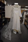 A vintage 1960/70s cream wedding dress with bell sleeves size 15' across chest with a veil and