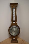 An early 20th Century oak barometer with silvered dial, measuring 60cm high