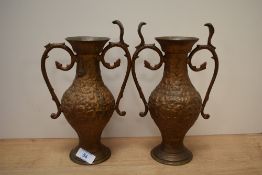 A pair of 19th/20th Century cast metal and twin handled vases, of Eastern design, each measuring