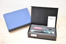 A boxed Opus 88 eyedropper fountain pen in green blue marbled having M Opus 88 nib.