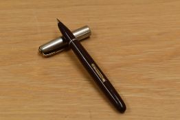 A Waterman Taperite lever fill fountain pen in brown having silver cap with gold trim.