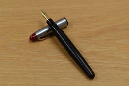 A Voss button fill fountain pen in black with brushed steel cap and red tassi with gold trim