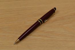 A Waterman Expert propelling pencil in red with gold trim.