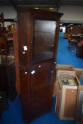 A period oak corner cupboard having glazed top section with enclosed panelled lower section,