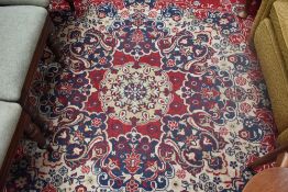 A vintage carpet square in tones of cobalt, claret and cream, approx 350cm by 240cm.