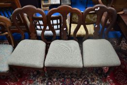 A set of four Victorian dining chairs having later tweed upholstery