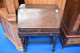 An 18th Century and later oak bureau on stand having twist frame, with fitted interior, Celtic