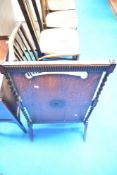 An early 20th Century oak fire screen having barley twist supports and applique decoration