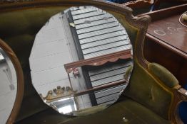 A 1930s frameless bevelled glass wall mirror, of round multi faceted form, 60cm.