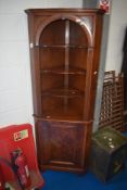 A reproduction corner shelf with cupboard to base, height approx 182cm