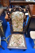 A 19th Century low chair having foliate and twist frame with later upholstery, prayer or nursing