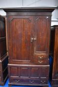 An 18th Century oak linen press having shelved cupboard and open interior over faux kist base,