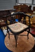 A Victorian ebonised corner armchair