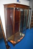 An early 20th century bow fronted glazed shop unit, approx 185cm high by 54cm deep and 105cm wide.