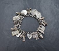 A silver charm bracelet with heart padlock and safety chain, having twenty-three white metal and