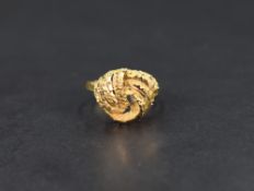 A high carat yellow gold ring, of a textured knot motif with a 9ct gold ring size reducer, ring size